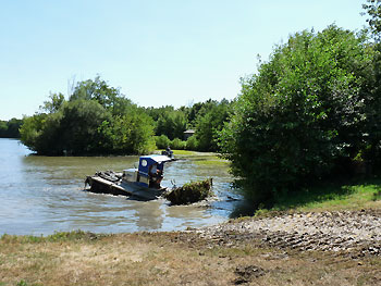 Retrait de la jussie à l'aide de machines amphibies © Estèle Guénin http://files.biolovision.net/vienne.lpo.fr/userfiles/travaux-jussie-2013.jpg
